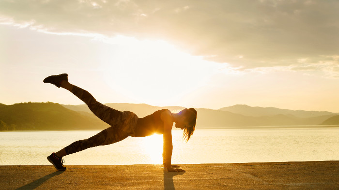 Lady doing yoga by the mountains